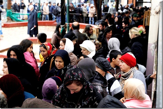 People wait in line to receive food from the Greek Orthodox Church in Athens, Thursday, Dec. 22, 2011. The leader of Greece's Orthodox Church is promising to boost its campaign to provide free meals to the poor and homeless amid the country's deepening financial crisis.(AP Photo/Petros Giannakouris)