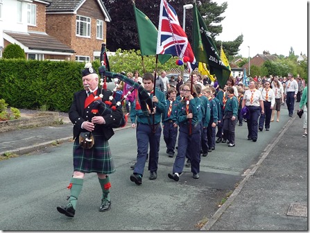 Scottish Piper Reg Flower leads the procession through Wistaston