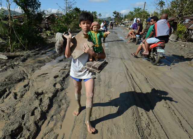 A resident carries a religious statue along a muddy road in the town of New Bataan, compostela province, 6 December 2012. Ted Aljibe / AFP / Getty Images