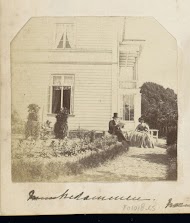 Man en een vrouw zittend op een terras voor een landhuis, vermoedelijk in Noorwegen