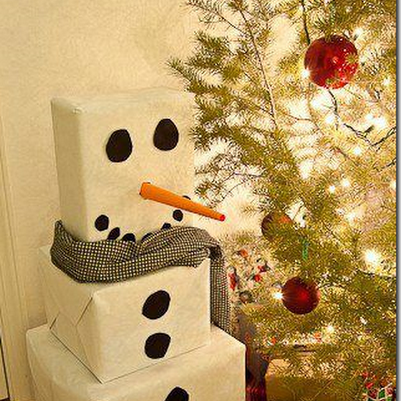 Muñeco de nieve cuadrado para los regalos junto al árbol