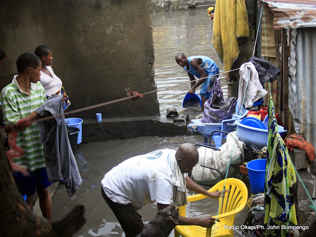 Une famille inondée par les eaux de pluie, tente de récupérer  leurs biens en évacuant les eaux stagnantes dans la parcelle. Radio Okapi/Ph. John Bompengo