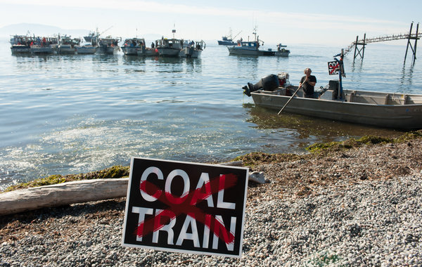 Chuck Boyer operated a skiff that brought people from their fishing boats to shore to watch speeches during a protest against the building of North America's largest coal terminal at Cherry Point, Washington, 11 October 2012. Paul Anderson for The New York Times