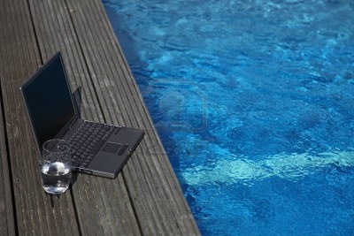 6275266-notebook-computer-lying-next-to-a-swimming-pool