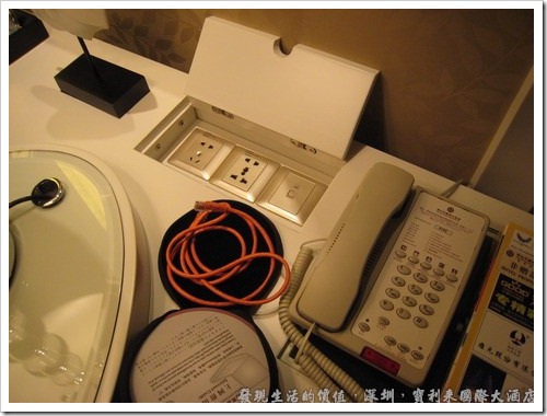 深圳寶利來國際大酒店，書桌旁還貼心的準備了萬用插座，其電壓當然都是220V，但現在的變壓器幾乎都是100～240V通吃，所以應該無所謂。網路接口當然也準備好囉！ 
