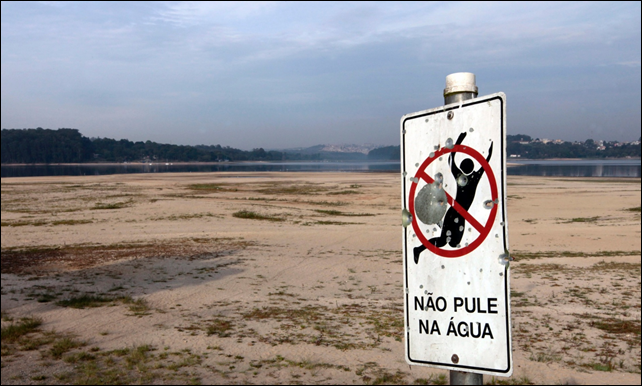 A sign reading 'Don’t jump in the water' at the dried up part of the Guarapiranga reservoir in November 2014. Photo: Paulo Whitaker / Reuters