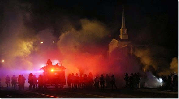 Tactical officers advance east on Chambers Ave. through clouds of tear gas as they try to clear protestors early on Wednesday, Aug. 13, 2014, in Ferguson.  It was the third night of unrest in Ferguson after the fatal police shooting of a teen on Saturday.Photo by Chris Lee, clee@post-dispatch.com