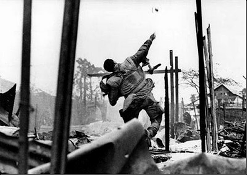 Viet-Nam, 1968. Marine américain lançant une grenade quelques secondes avant d'être blessé à la main gauche par un tir, offensive du Têt, Hué.
