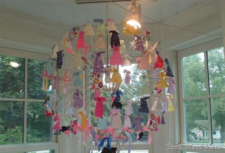 hanging artwork made up of fabric pieces cut to look like clothing