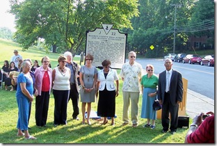 Former students posing in front of the marker after ceremony.