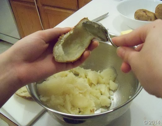 Scooping out potatoes for Deluxe Potato Skins Recipe