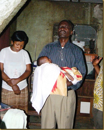 Pastor Kayembe praying for baby Ndumba