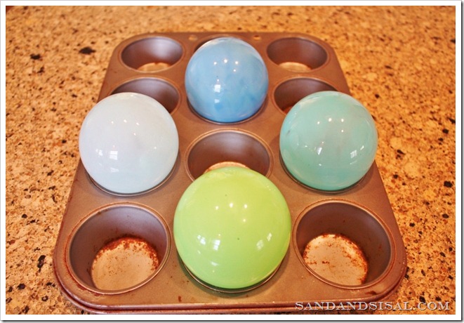 Place glass floats on cupcake pan to bake