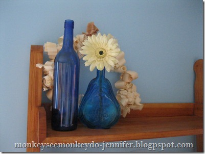 textured wreath display with blue glass bottles and flower