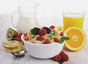 Colazione di cereali, frutta, arancia, latte e miele Colazione di cereali, frutta, arancia, latte e miele