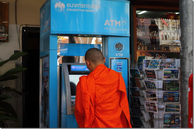 Buddhist monk uses a ATM at Chiang Mai, Thailand