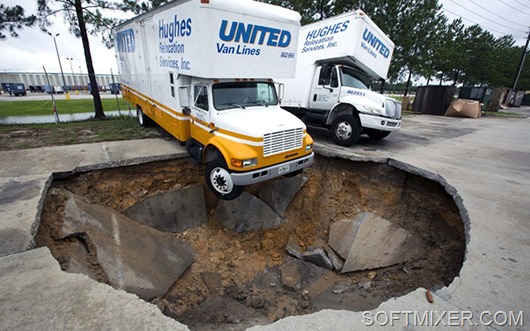 A truck hangs over the edge of a sinkhole that opened up in the parking lot of Hughes Relocation Services, Monday, June 25, 2012, in Salt Springs, Fla. Tropical Storm Debby raked the Tampa Bay area with high wind and heavy rain Monday in a drenching that could top 2 feet over the next few days and trigger widespread flooding. (AP Photo/The Ocala Star-Banner, Alan Youngblood)