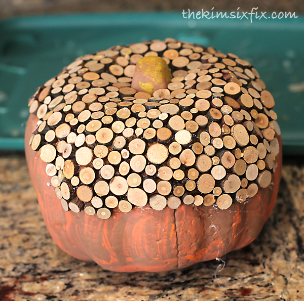 Gluing wood slices to pumpkin