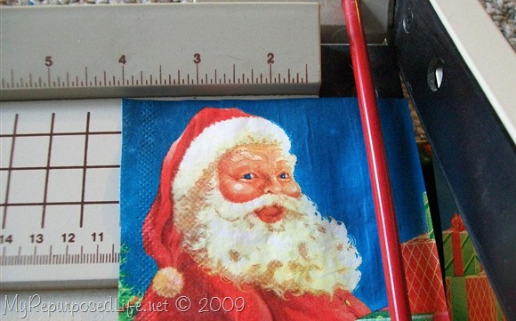 using a paper cutter to cut a napkin santa Christmas napkin