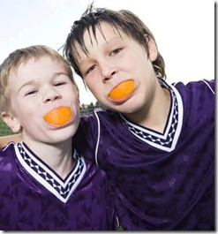 two boys with orange wedges