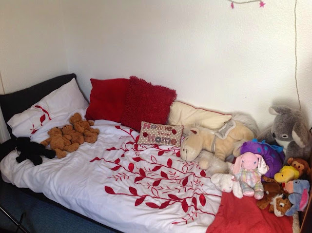 child's bed with cuddly toys and bears