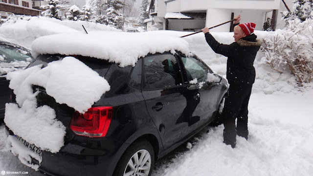 removing snow from car in Seefeld, Austria 