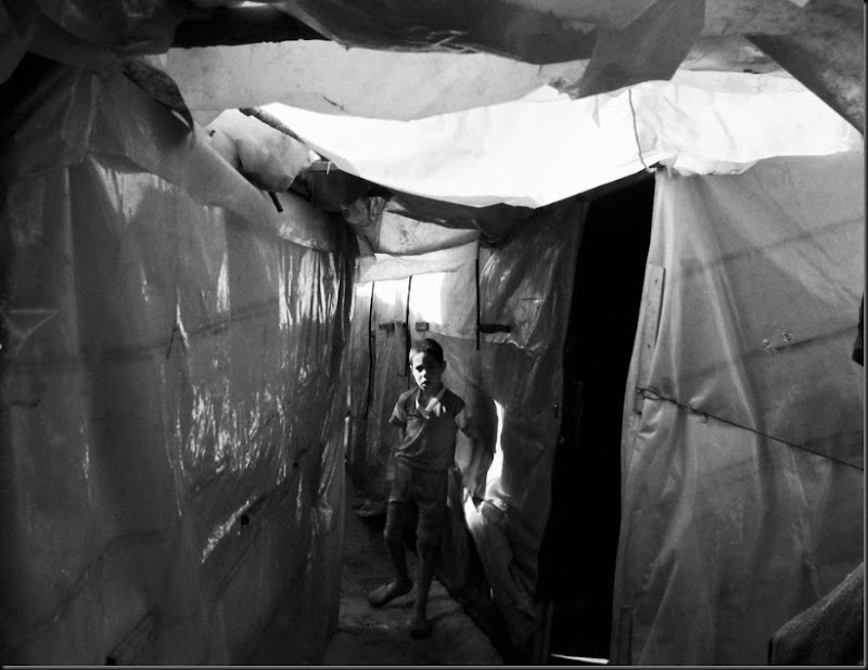 A Syrian boy inside a tent settlement in northern Lebanon. (Moises Saman/Magnum Photos for Save the Children)
