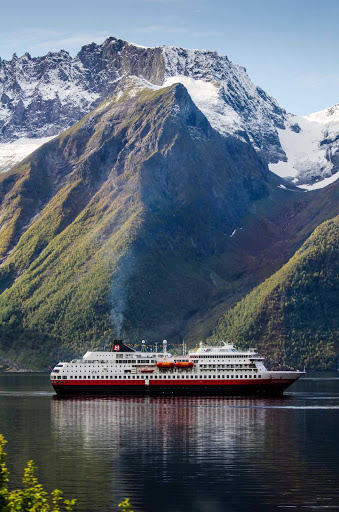 Cruise down Norway's Hjørundfjorden fjord and revel in the dramatic mountain scenery from the deck of Hurtigruten's ms Finnmarken.