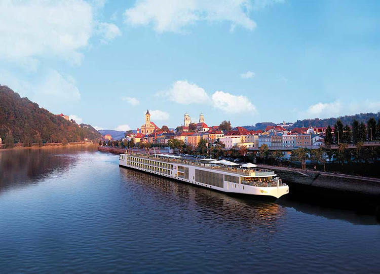 A Viking Longship sails through a charming village. A typical itinerary will allow passengers to spend the better part of a day exploring cities, towns, castles and museums with a guide or on their own. 