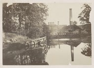 Fabrieksgebouw met een schoorsteen aan een water