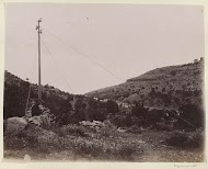 Reiziger op een rots bij een telegraafpaal in een landschap in Perzië