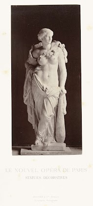 Marmeren beeld van een vrouw met ontblote borsten en in haar hand een knuppel.