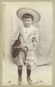 Portret van een kind met een tas, een matrozenpakje en een zonnehoed