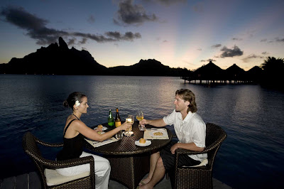 Enjoy a sunset dinner at the St. Regis Bora Bora Resort during your cruise vacation.