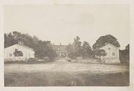 Onverharde weg met aan weerszijden en aan het einde huizen