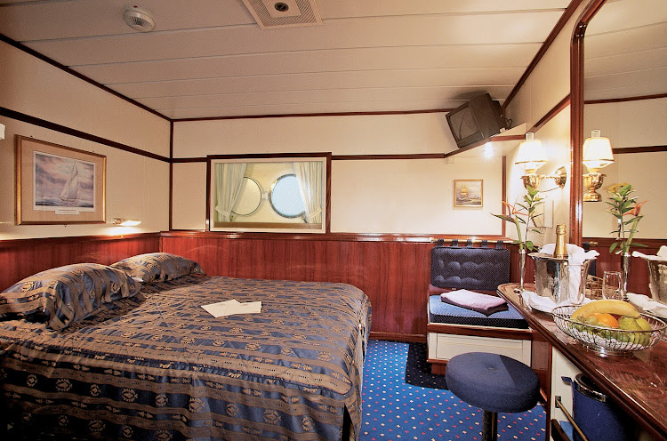 The Owner's Suite aboard Star Clipper and Star Flyer offers   guests a spacious bedroom with a small television, vanity area and king-size bed.