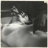 Liggende, lachende vrouw, met haar hoofd naar rechts en een vinger in haar navel.