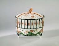 Cilidrical covered box in the shape of a cricket's cage