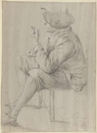 Pijprokende zittende man met baret van opzij gezien