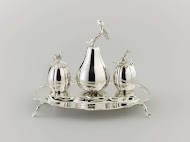 Inktstel van zilver. Blad met uitgebogen voorzijde; inktpot en zandstrooier meloenvormig, tafelbel peervormig