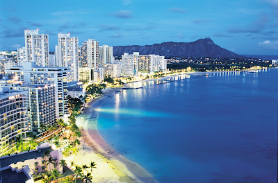View of world-famous Waikiki Beach with Diamond Head, known locally as Leah, serving as backdrop at dusk.