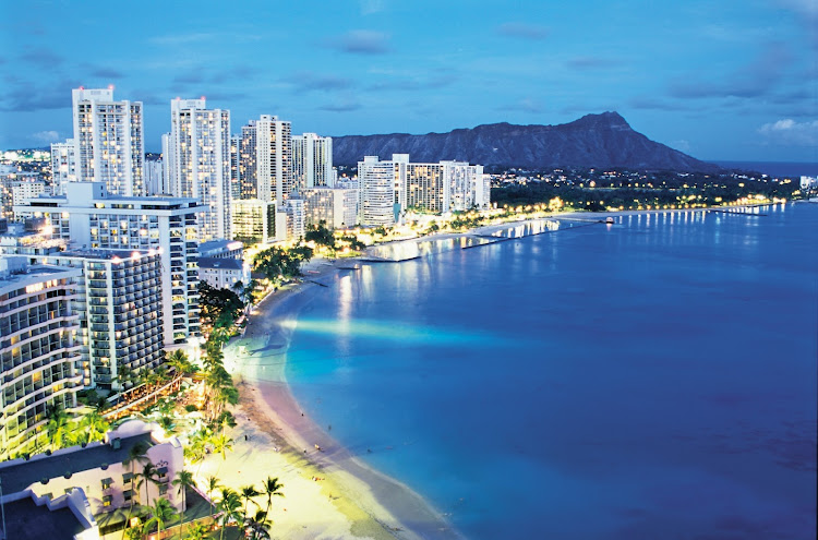 View of world-famous Waikiki Beach with Diamond Head, known locally as Leah, serving as backdrop at dusk.