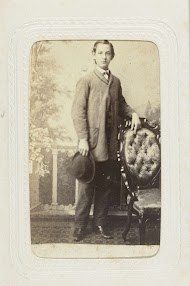 Studioportret van een jongeman met hoed in de hand