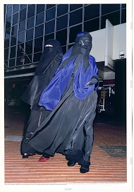 Twee vrouwen in niqaab op weg naar huis na het winkelen