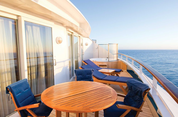 Lounge on the balcony with a cool drink while waiting for the sun to set when staying in the  Owner's Suite aboard Norwegian Sky. 