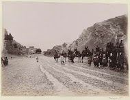 Ruitergezelschap verlaat Shiraz, op de achtergrond de Koranpoort