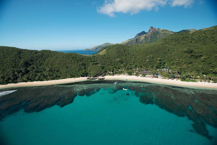 A perfectly still inlet serves as a mirror for Fiji's lush scenery.