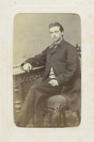 Studioportret van een man bij een tafel met ornamenten