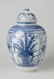 Ovoid covered jar with flowering plants near rocks and lotus scrolls