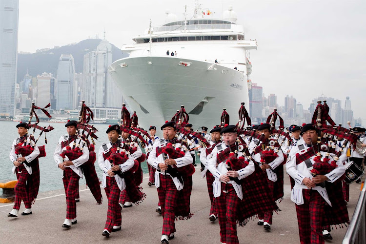 A bagpipe band welcomes a cruise ship to Hong Kong.
